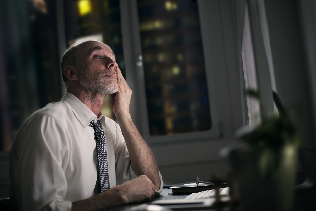 tired older man sitting in front of his computer