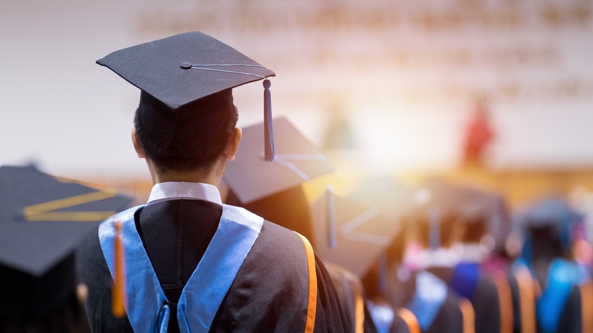 Rear view of university graduates wearing graduation gown and cap