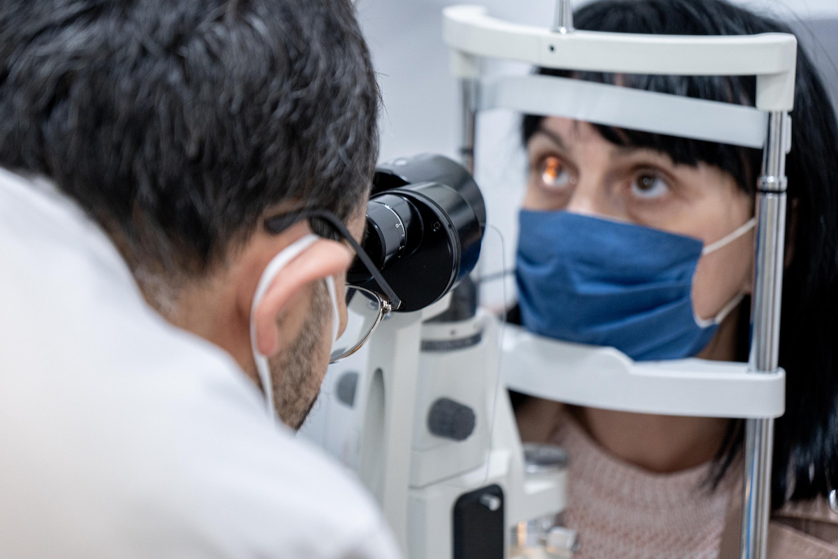 Optician examining woman's eyes