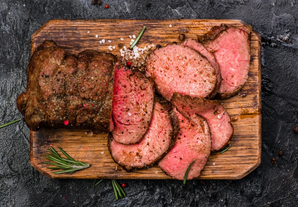 sliced roast beef on a wooden cutting board