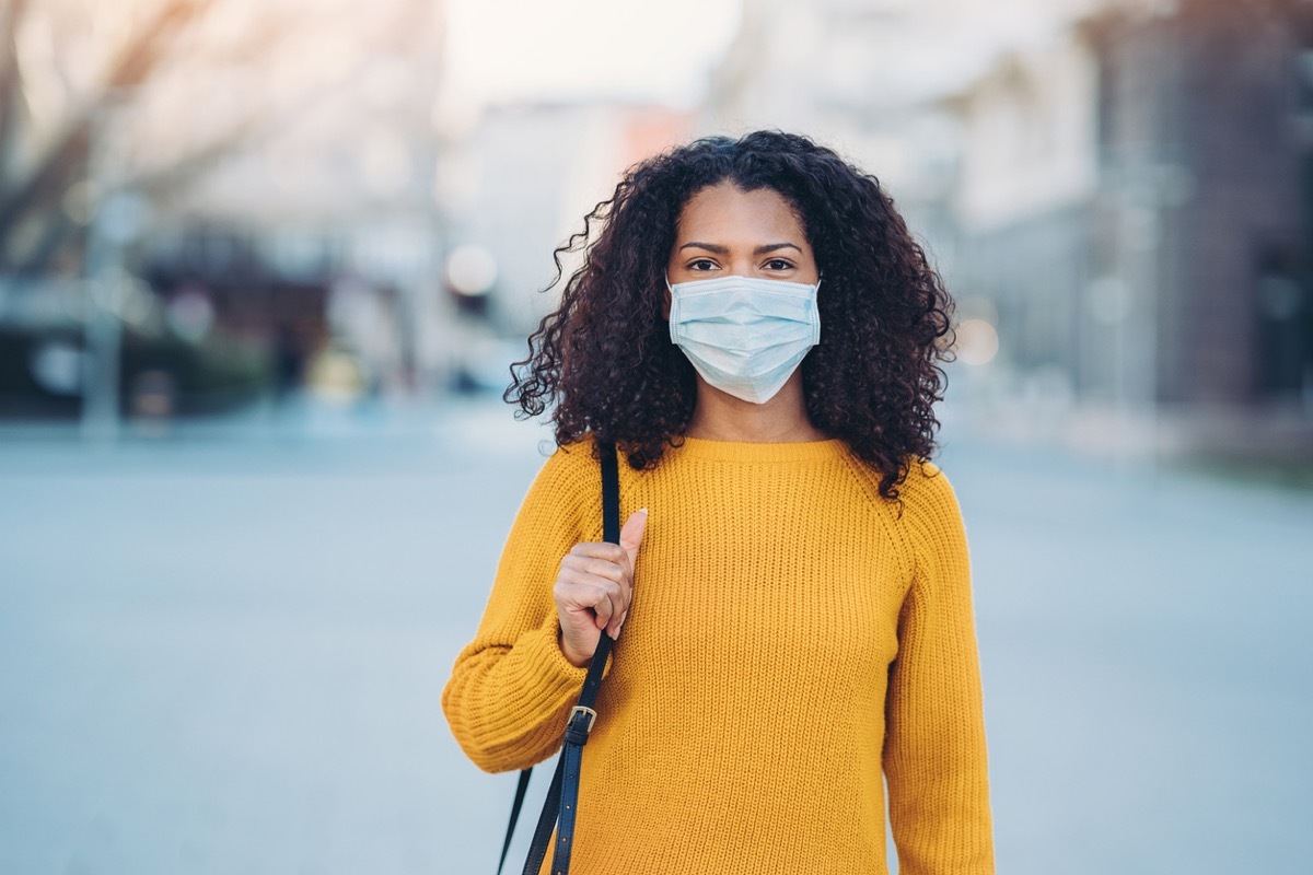 young black woman with face mask looking at camera