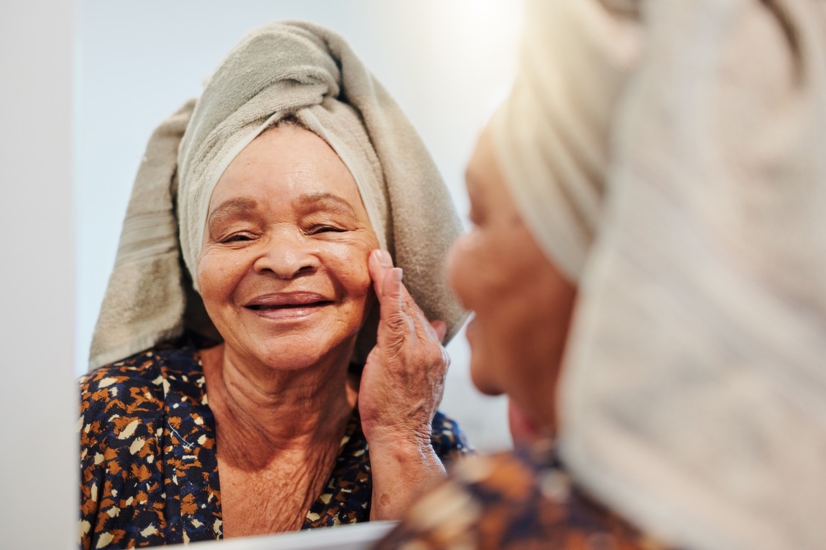 Shot of a mature woman applying her skincare in the bathroom