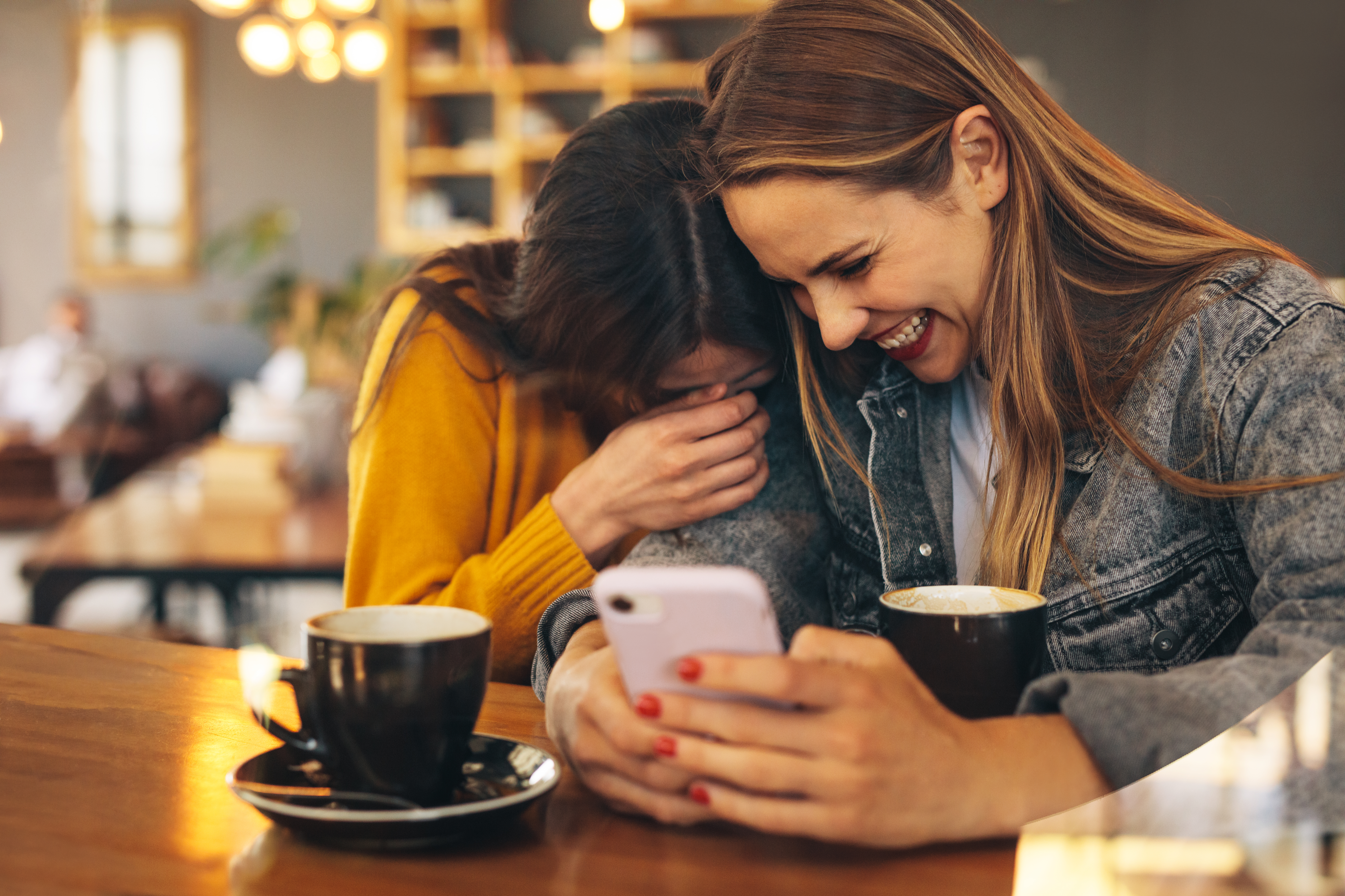 two women enjoying their morning coffee and laughing