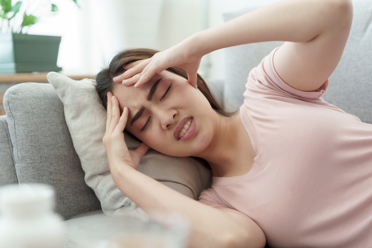 woman with a headache on her couch