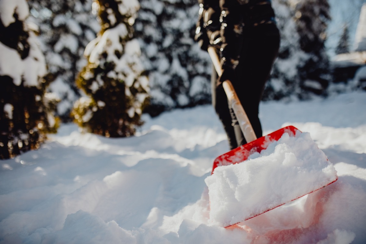 Public service worker or citizen shoveling snow during heavy winter blizzard