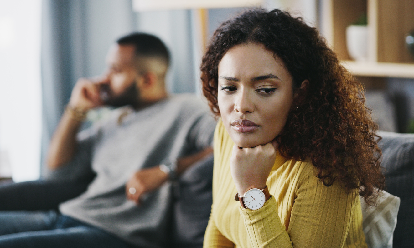 Couple sitting on couch, the woman looking away.