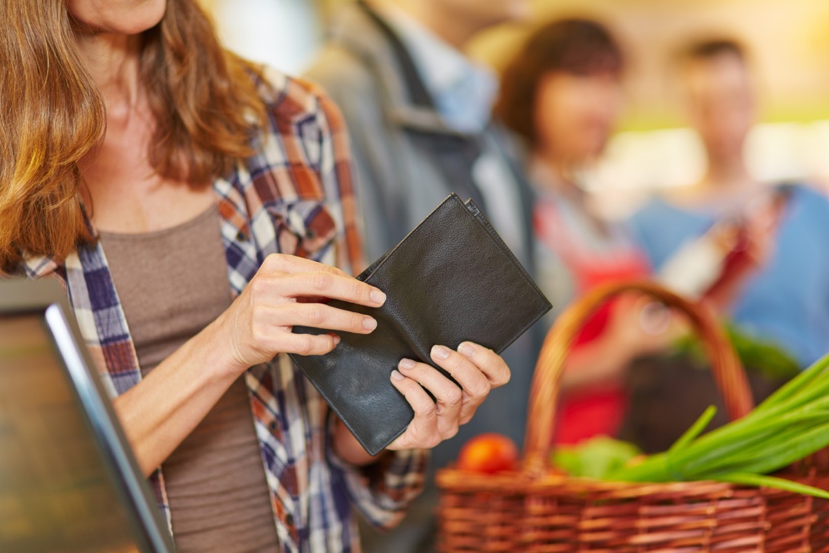 checking wallet at the grocery line