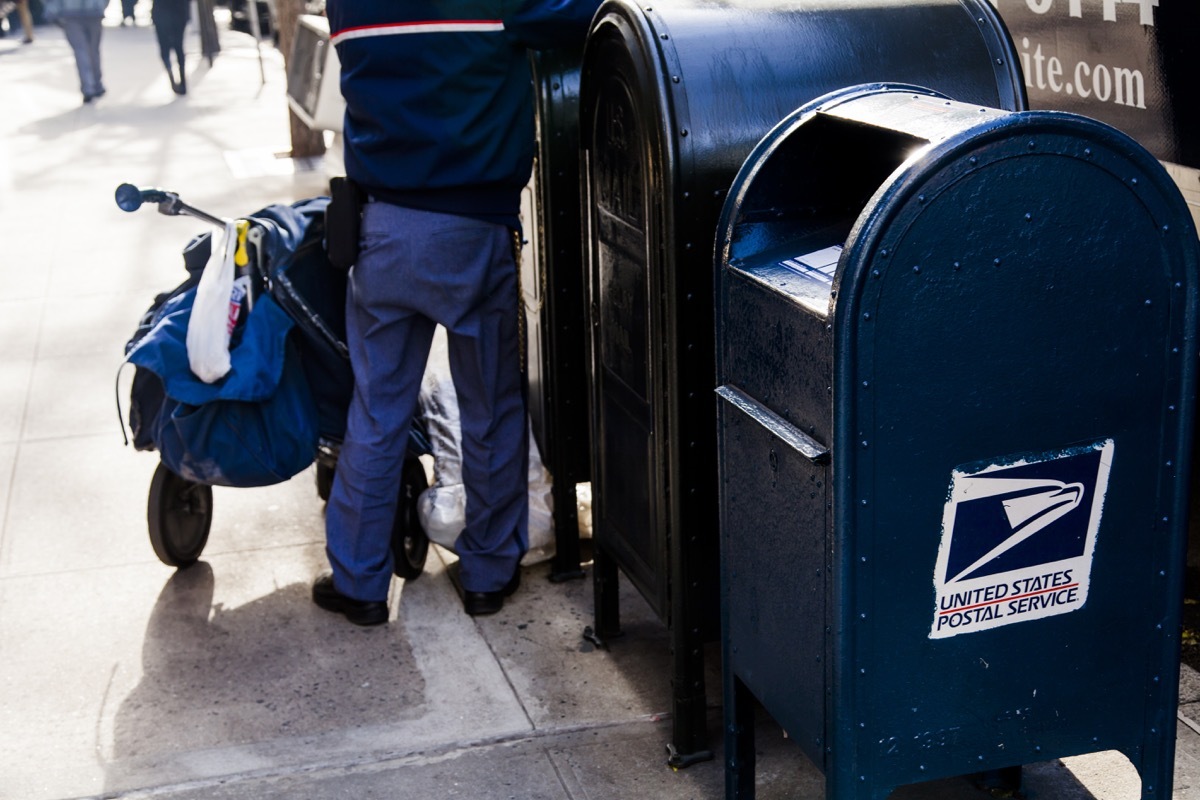 USPS worker emptying the mailbox on a MAnhattan street in New-York, USA on November 17, 2012.