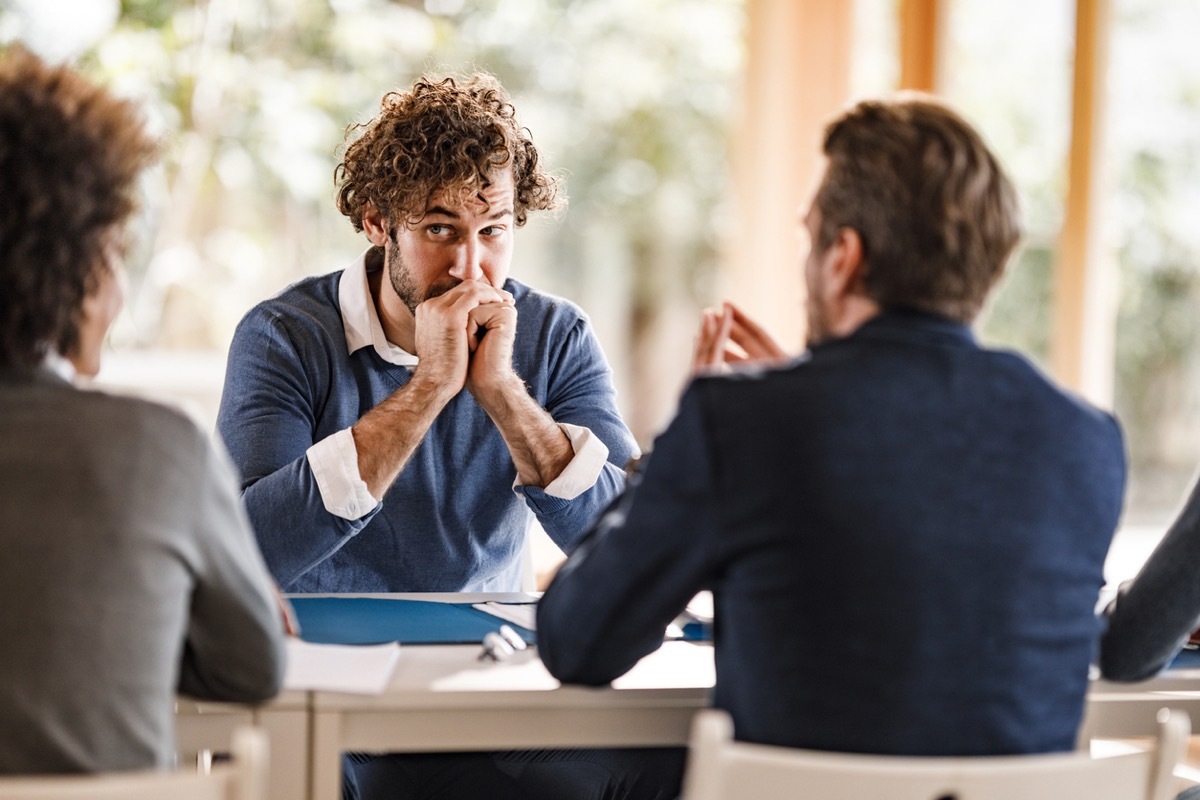 Worried male candidate waiting for human resource's decision on a job interview in the office.