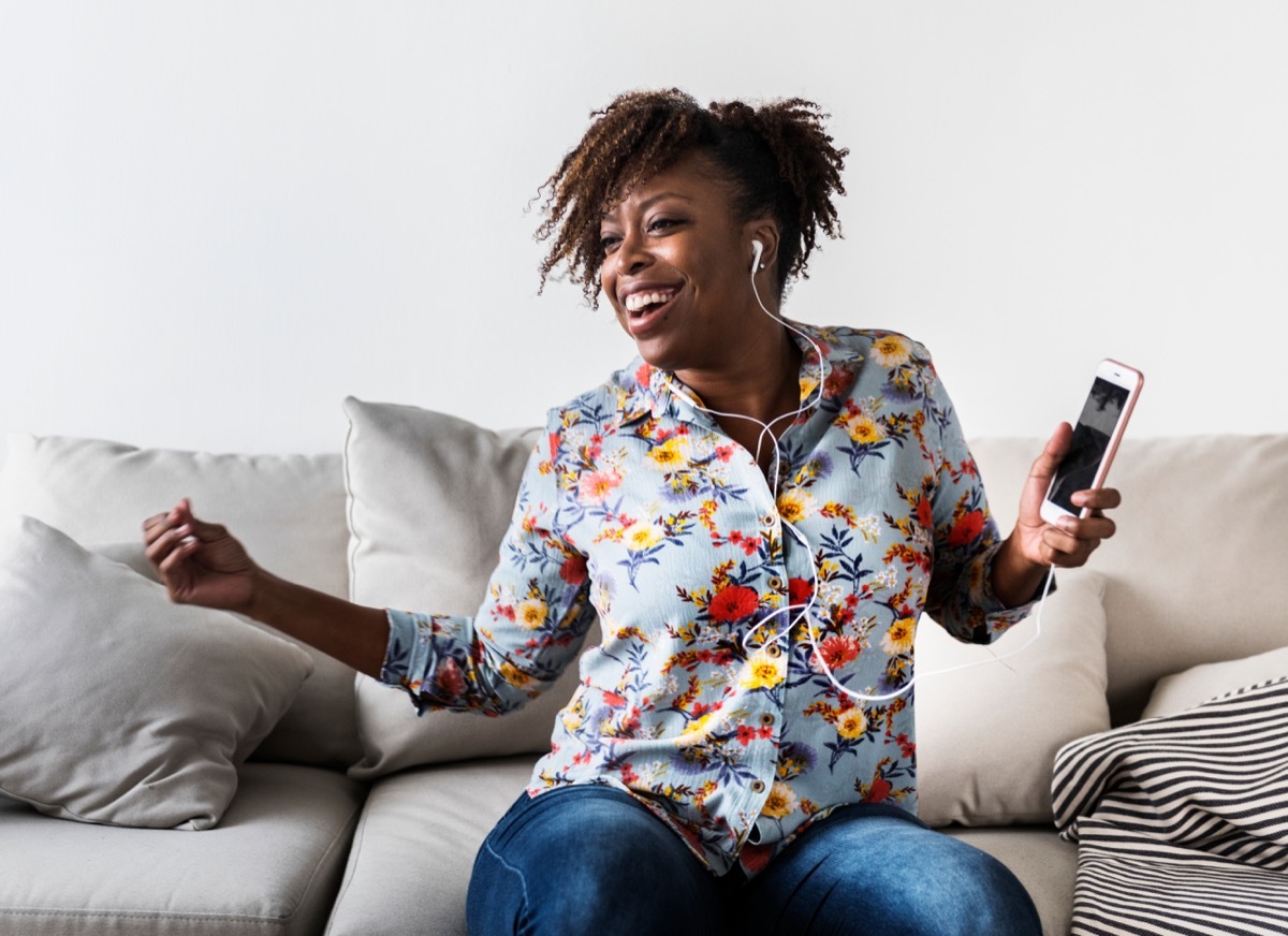 woman dancing alone listening to music with her headphones, stay younger