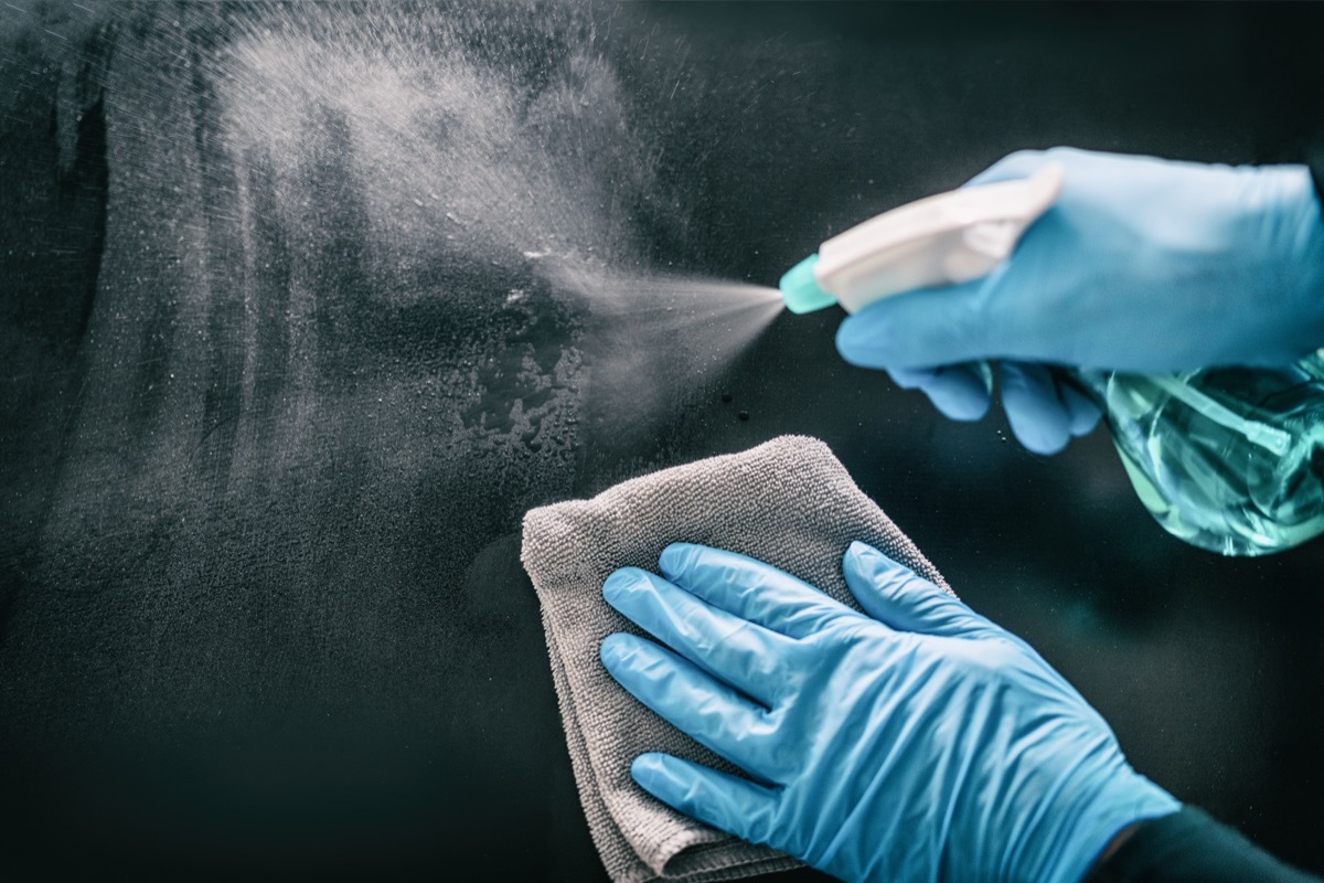 hands in blue nitrile gloves cleaning surface