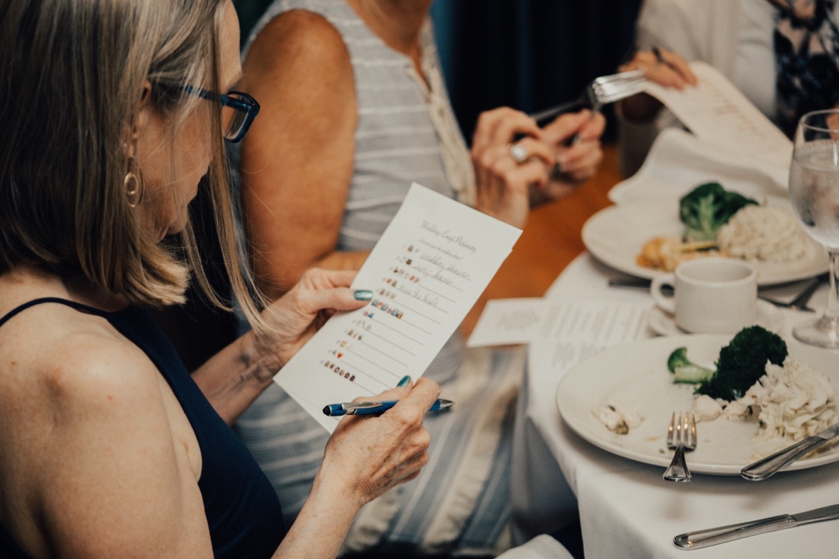 women sitting at a table playing bridal shower games