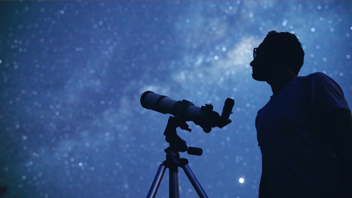 Man Stargazing with a Telescope