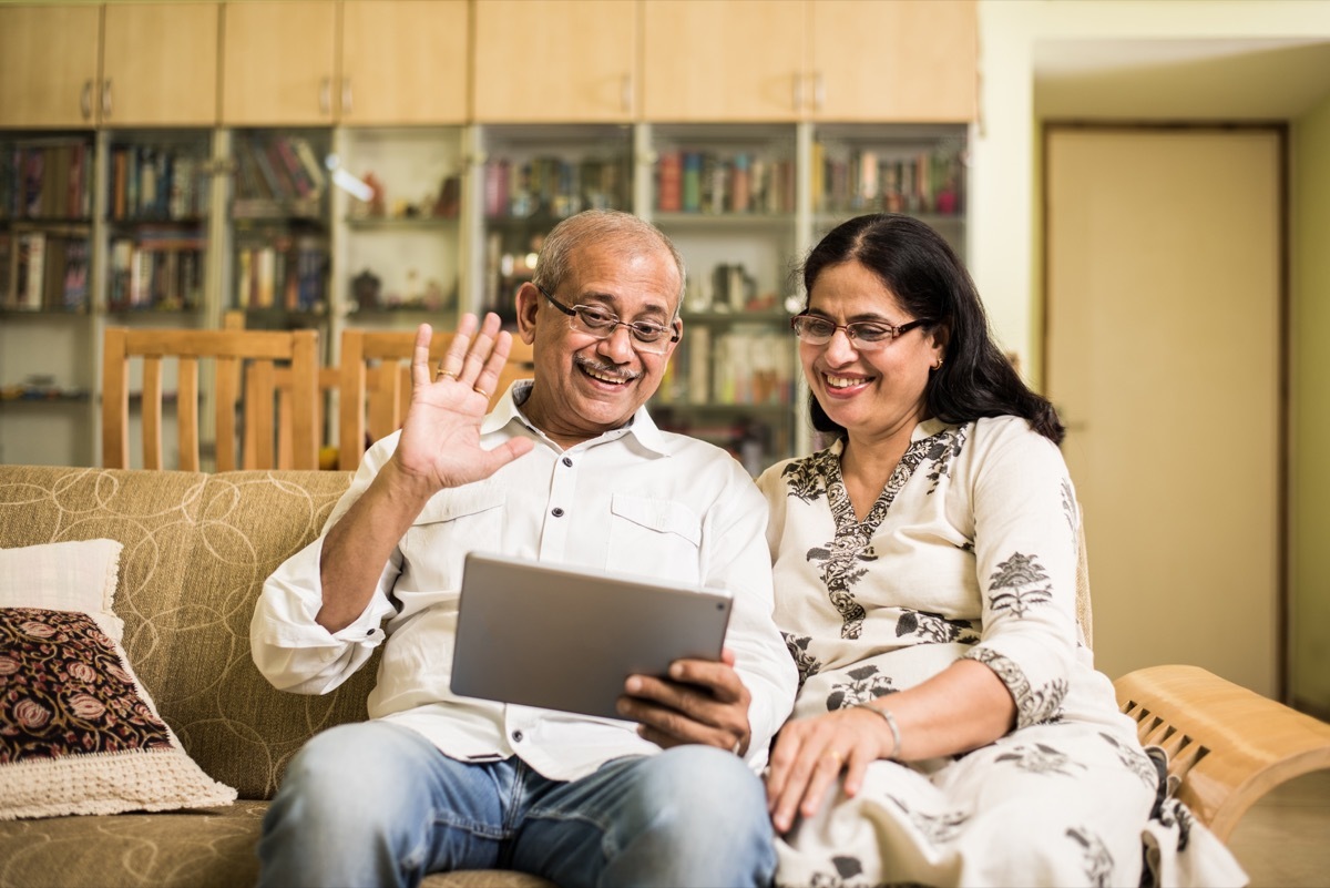 older indian couple using tablet to video chat