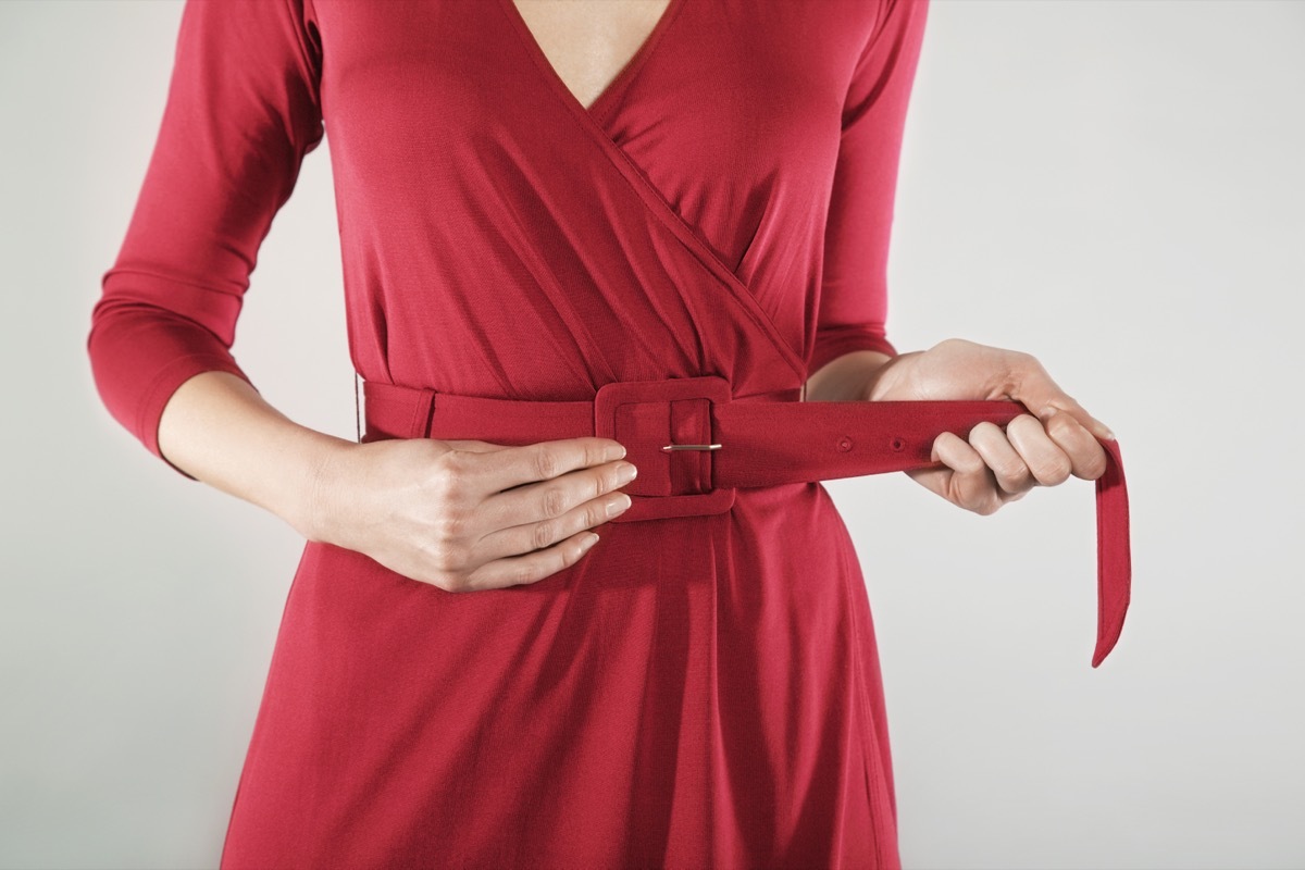 woman putting on red wrap dress