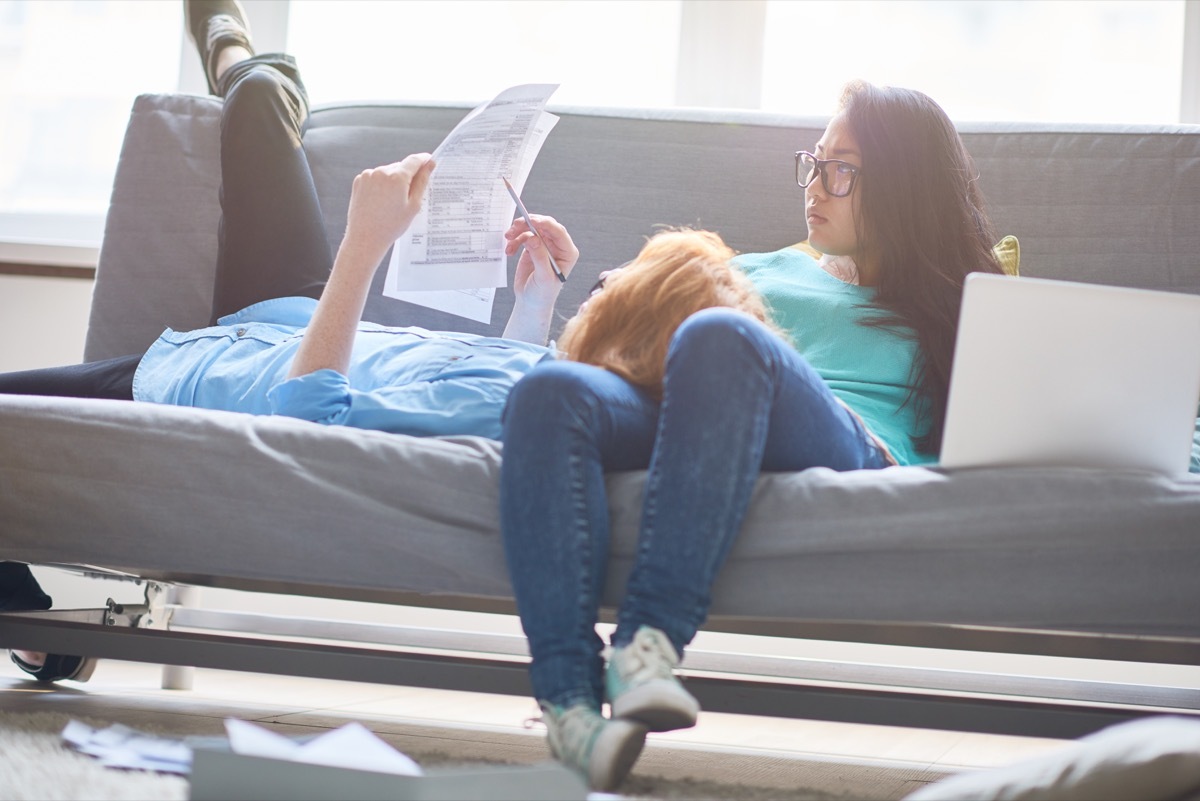 couple examining tax papers and relaxing on sofa at home