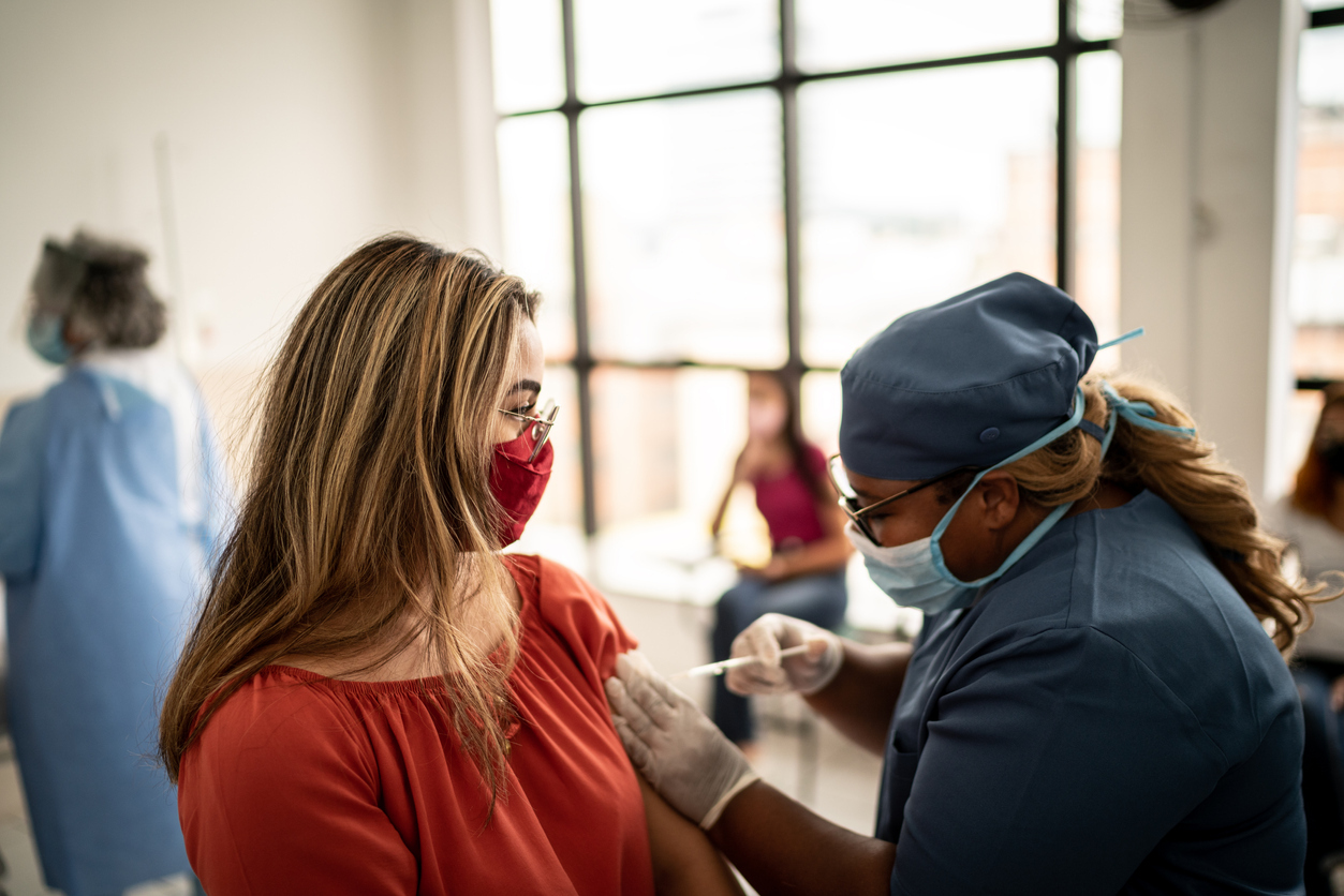 A healthcare worker giving a COVID or Monkeypox vaccine to a woman