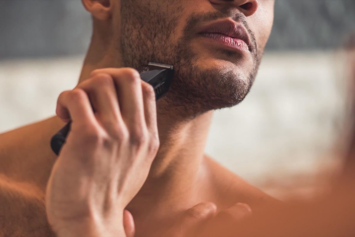 man shaving using an electric razor