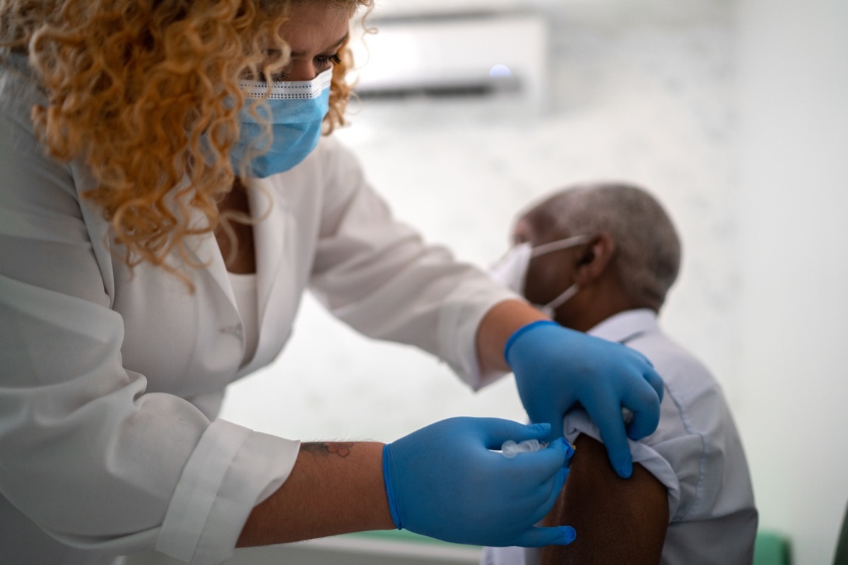 Nurse applying vaccine on patient's arm