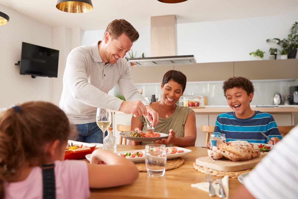 Multicultural family eating dinner together