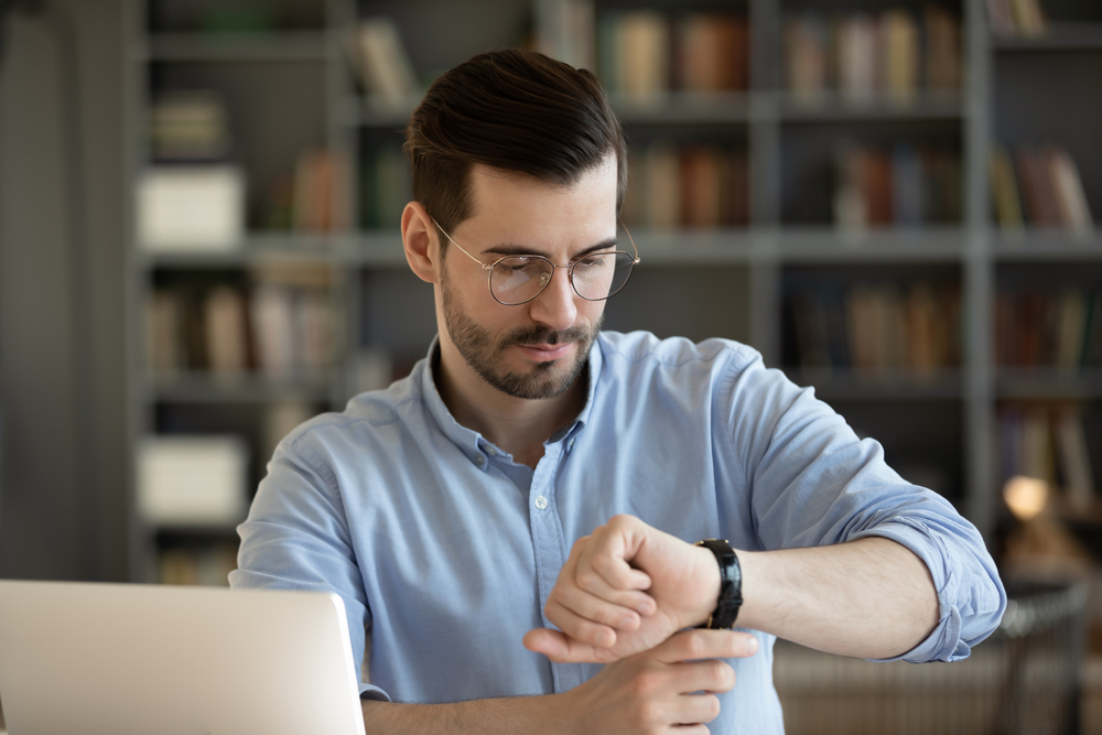 man looking at his watch in the office