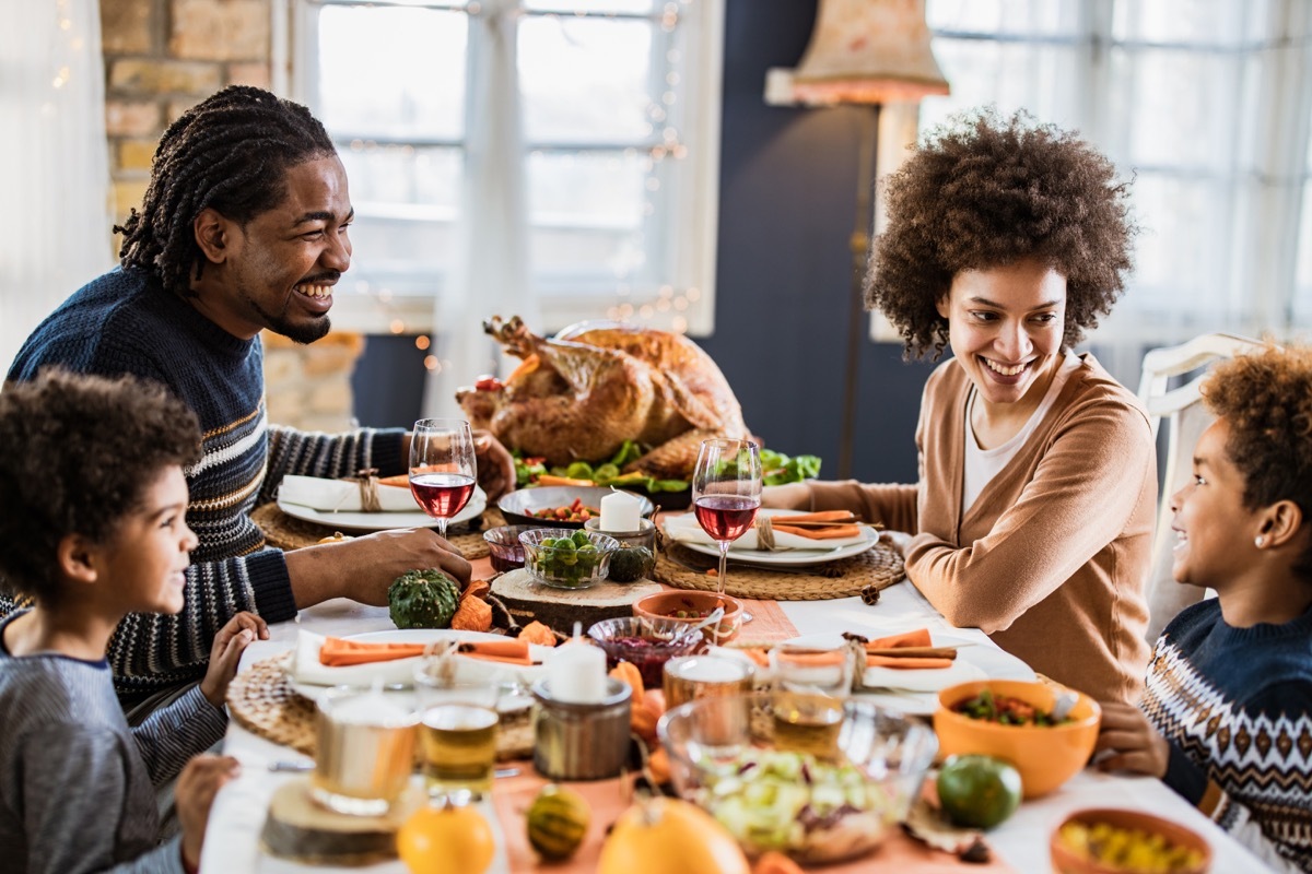 Family sitting around the table and celebrating Thanksgiving