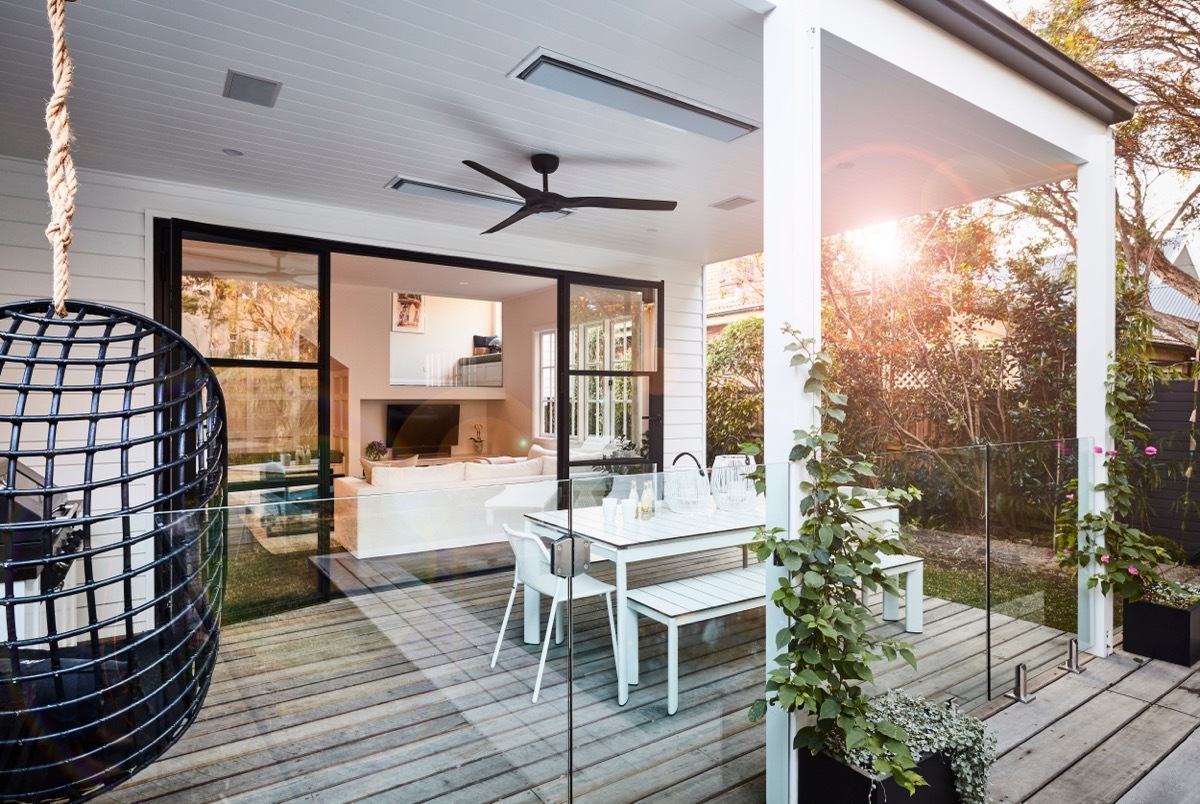 Lifestyle photography of an outdoor poolside patio area in a stylish modern coastal style home, shot late afternoon