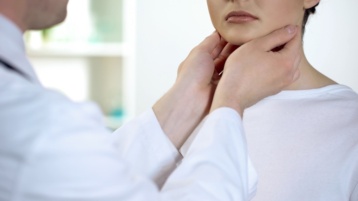 Woman getting her thyroid checked by a doctor