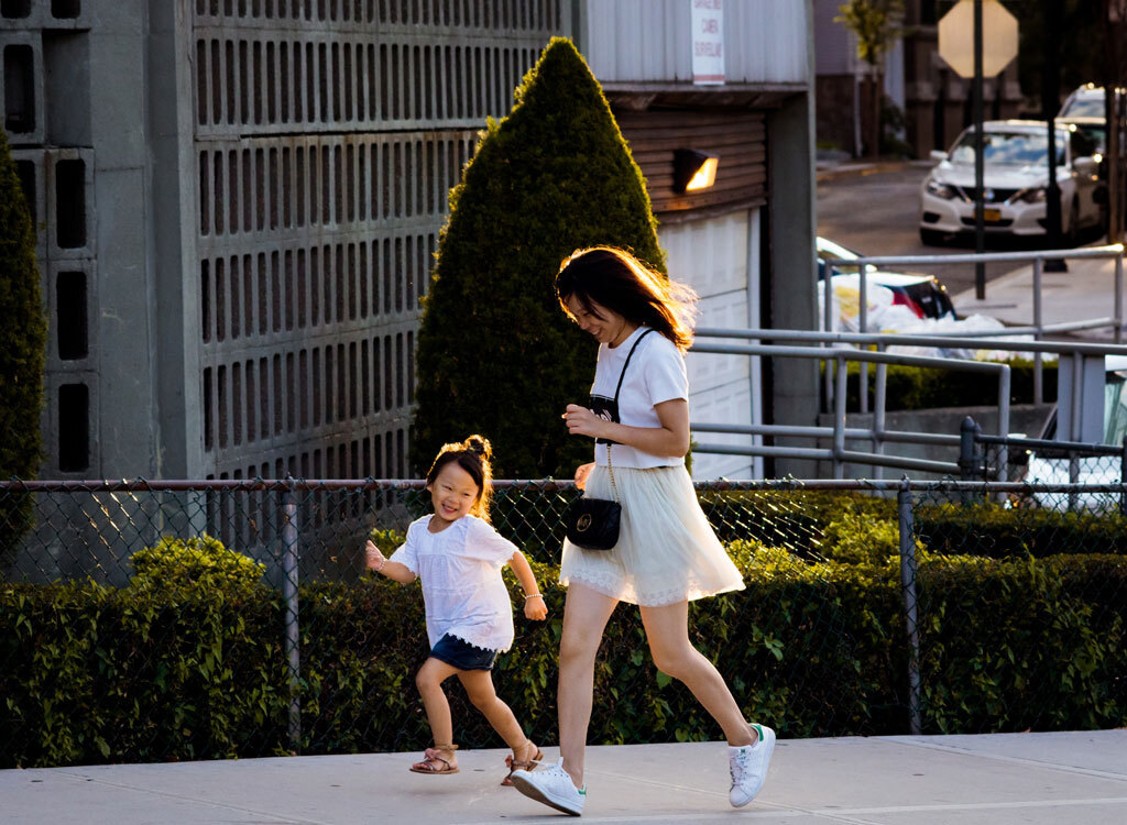 Woman and daughter running uphill