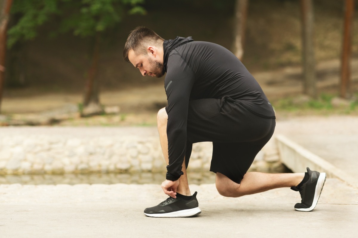 Male athlete tying running shoes lases getting ready for run