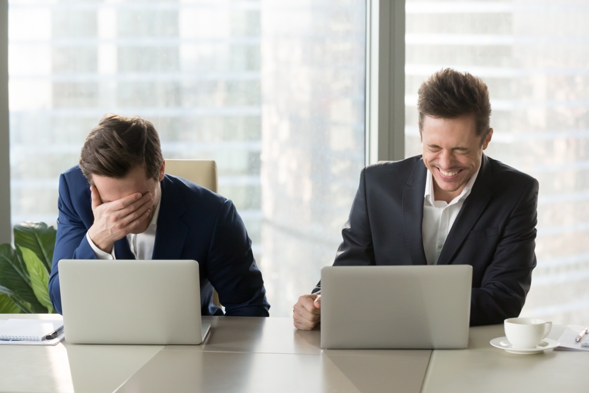 One Man Laughing While the Other Hides Face