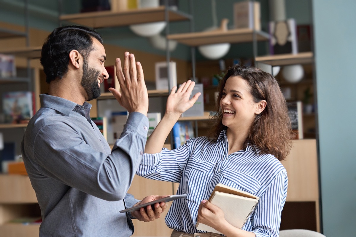 Two People Smiling and High Fiving