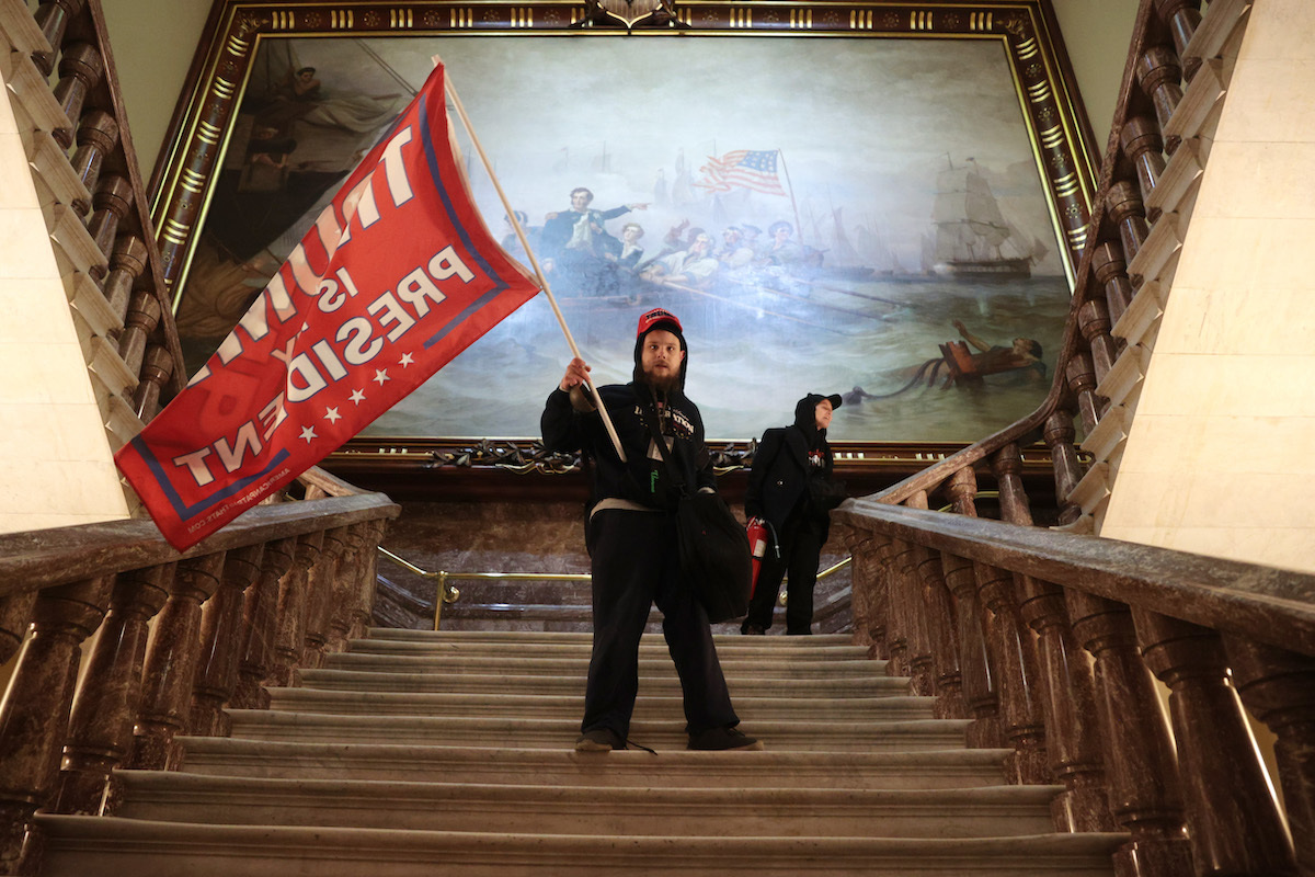 A protester holds a Trump flag inside the US Capitol Building near the Senate Chamber on January 06, 2021 in Washington, DC. Congress held a joint session today to ratify President-elect Joe Biden's 306-232 Electoral College win over President Donald Trump. A group of Republican senators said they would reject the Electoral College votes of several states unless Congress appointed a commission to audit the election results.