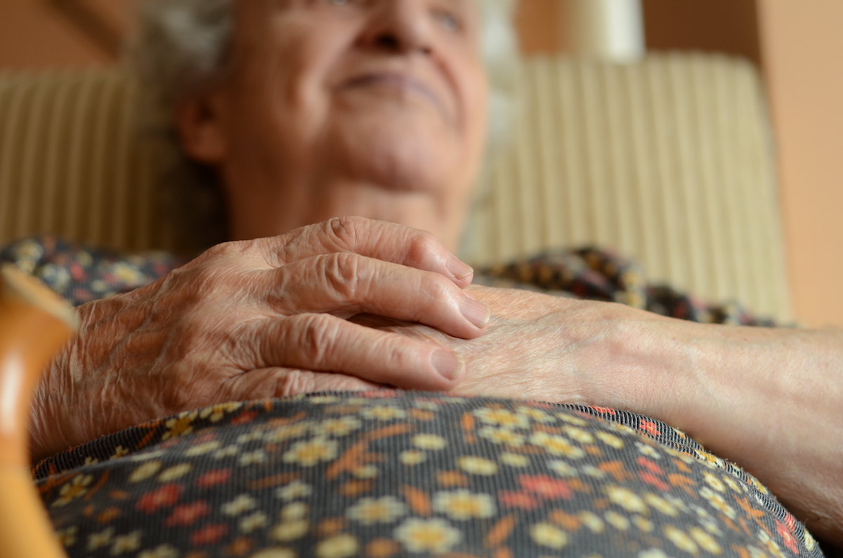 senior woman laying down on couch