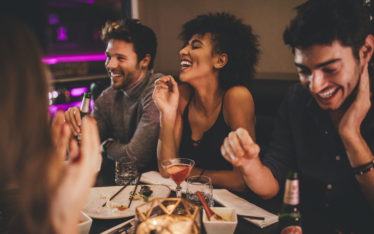 Group of friends enjoying a late evening meal in a restaurant.