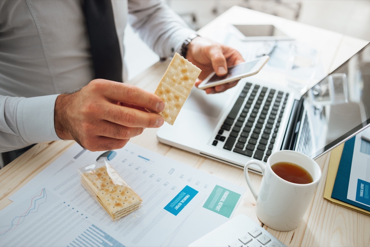 man snacking at work signs of burnout