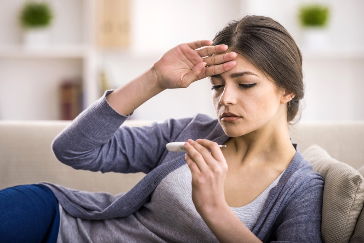 Woman taking her temperature to check for a fever