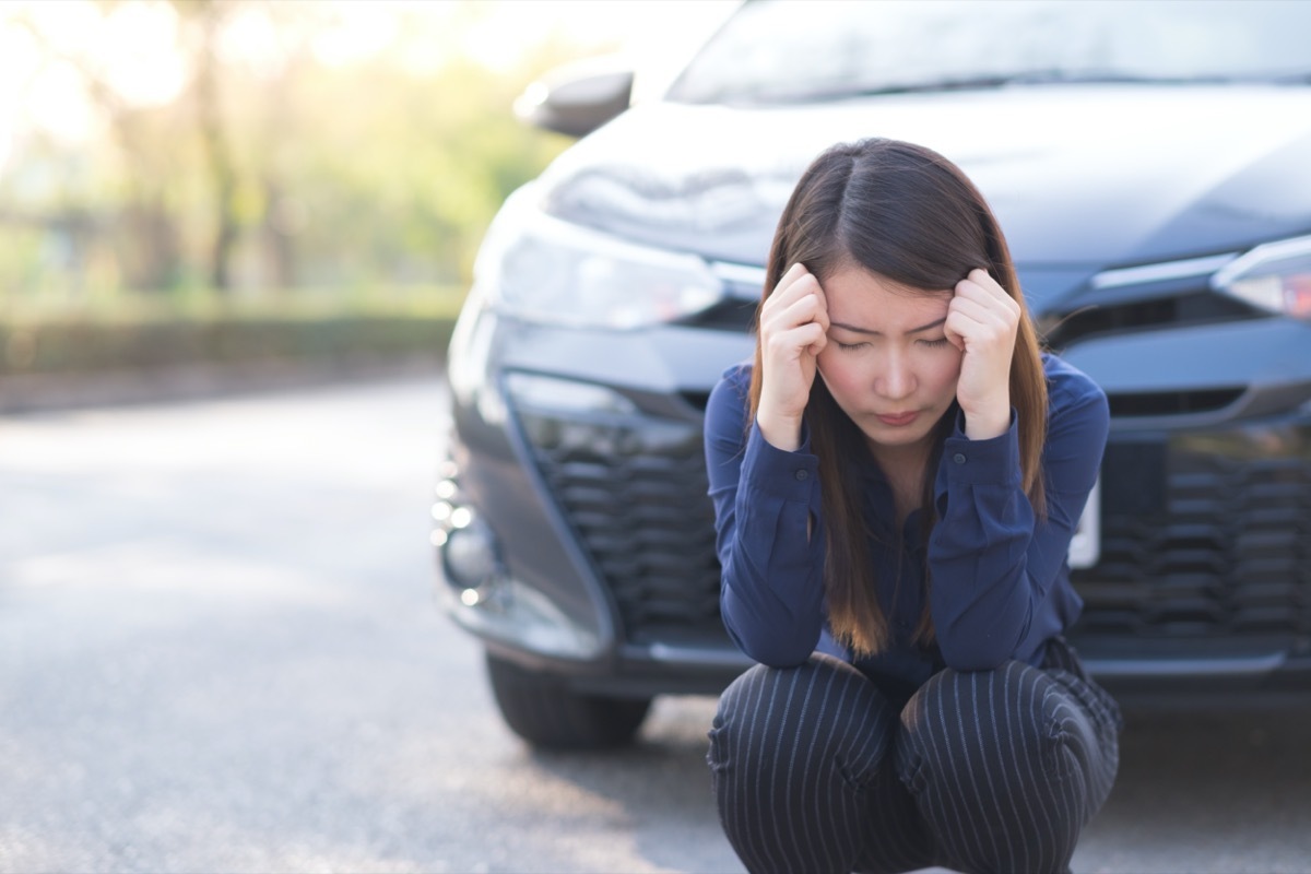 young asian woman upset after car accident