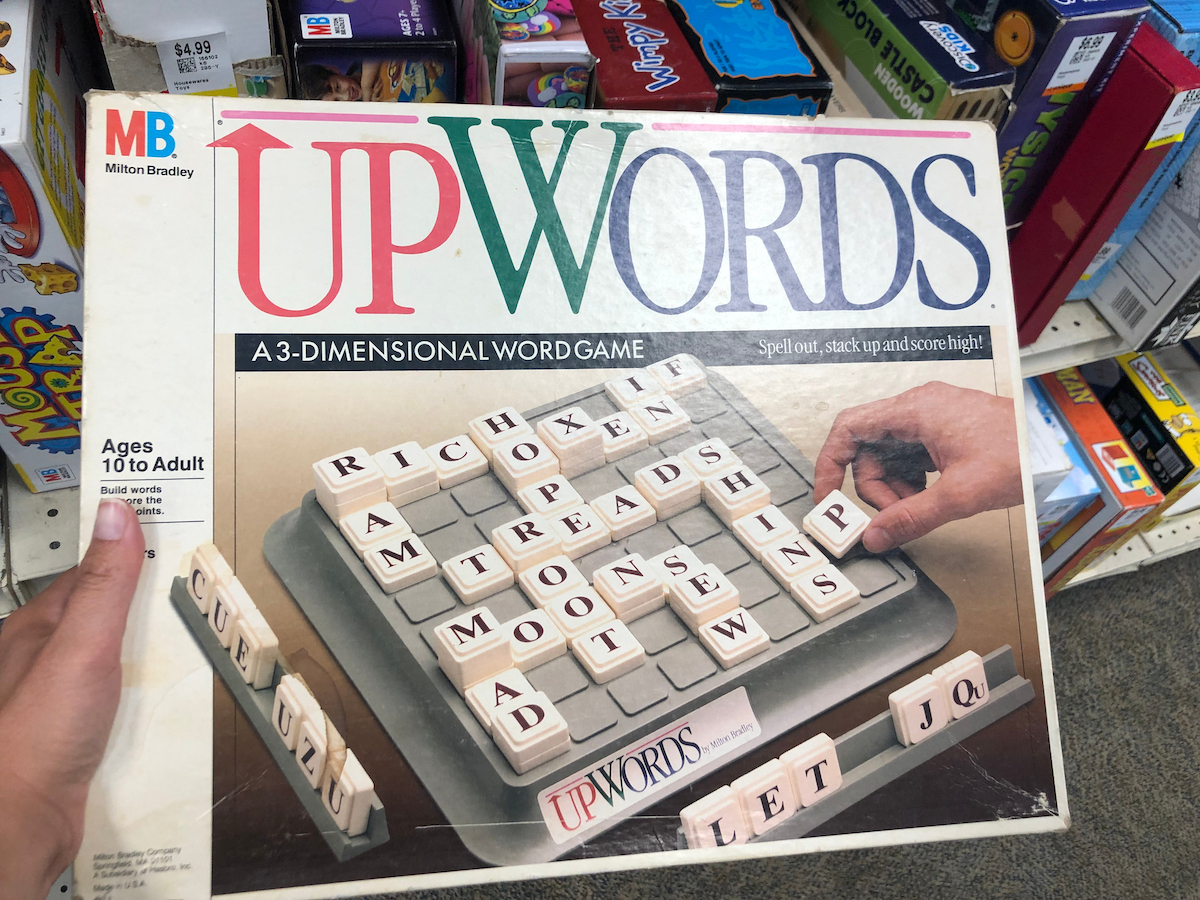 Hand holds up the vintage board game UpWords