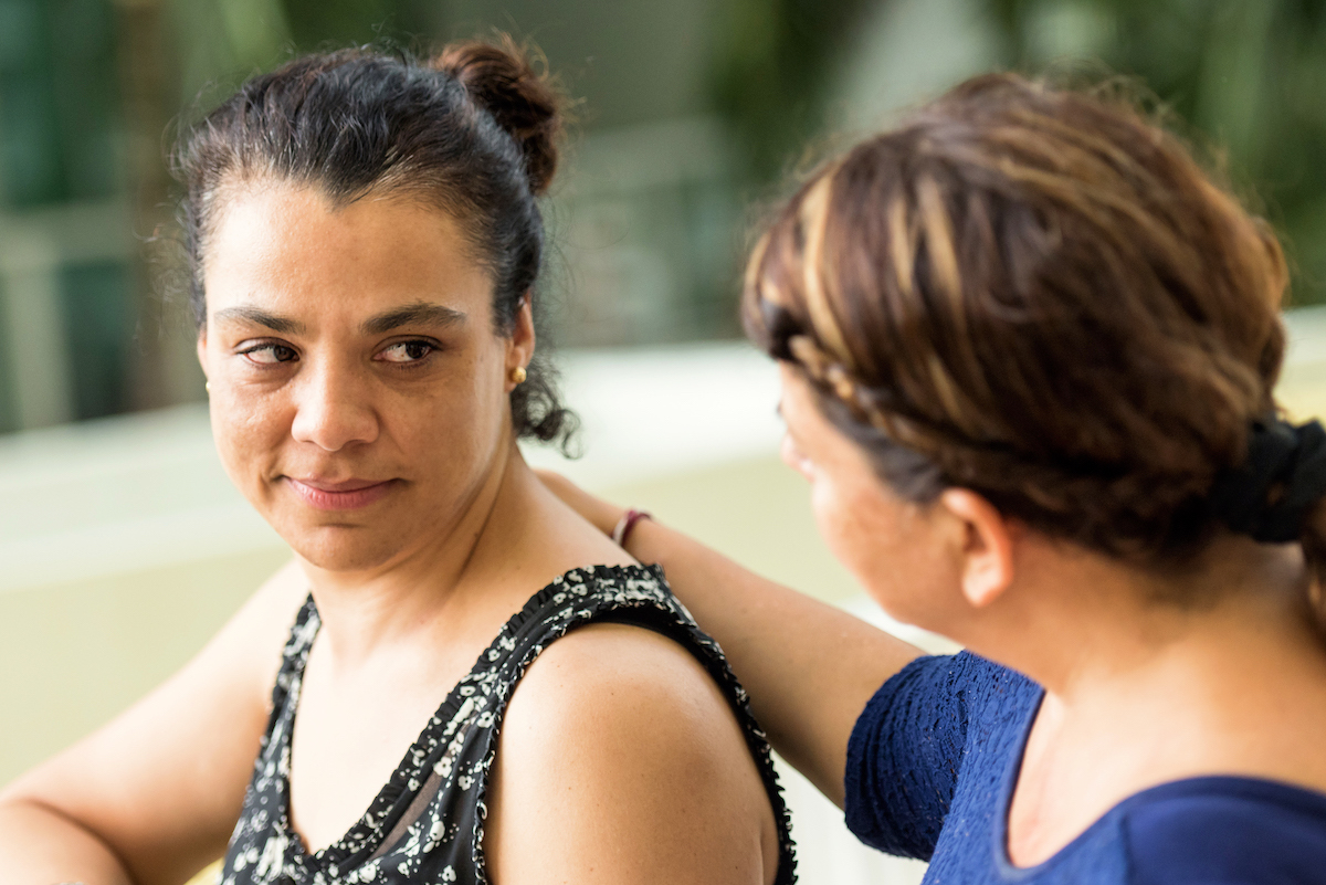 Sad Latinx woman being comforted by a friend