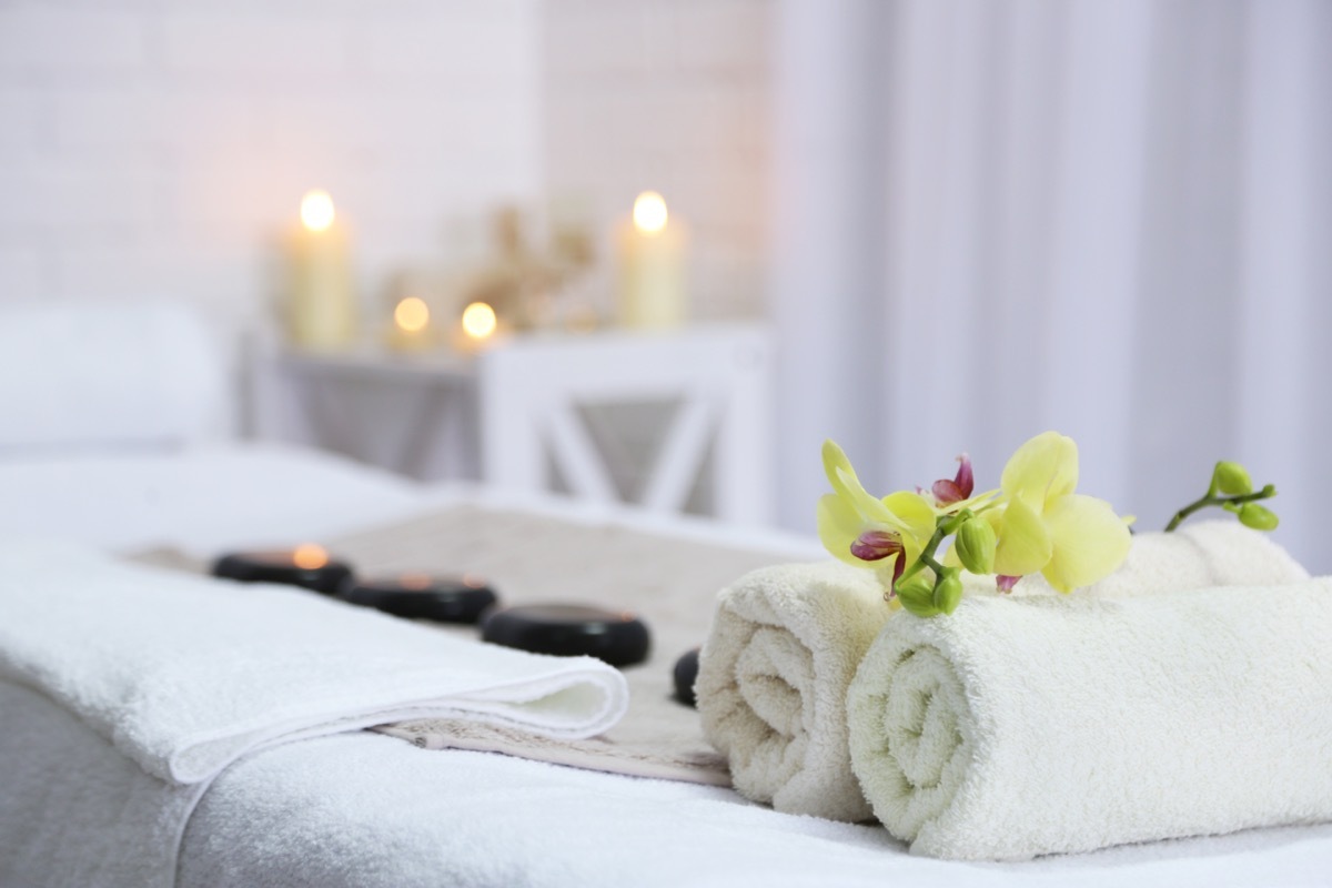 Towels and Stones Laid Out on a Massage Bed