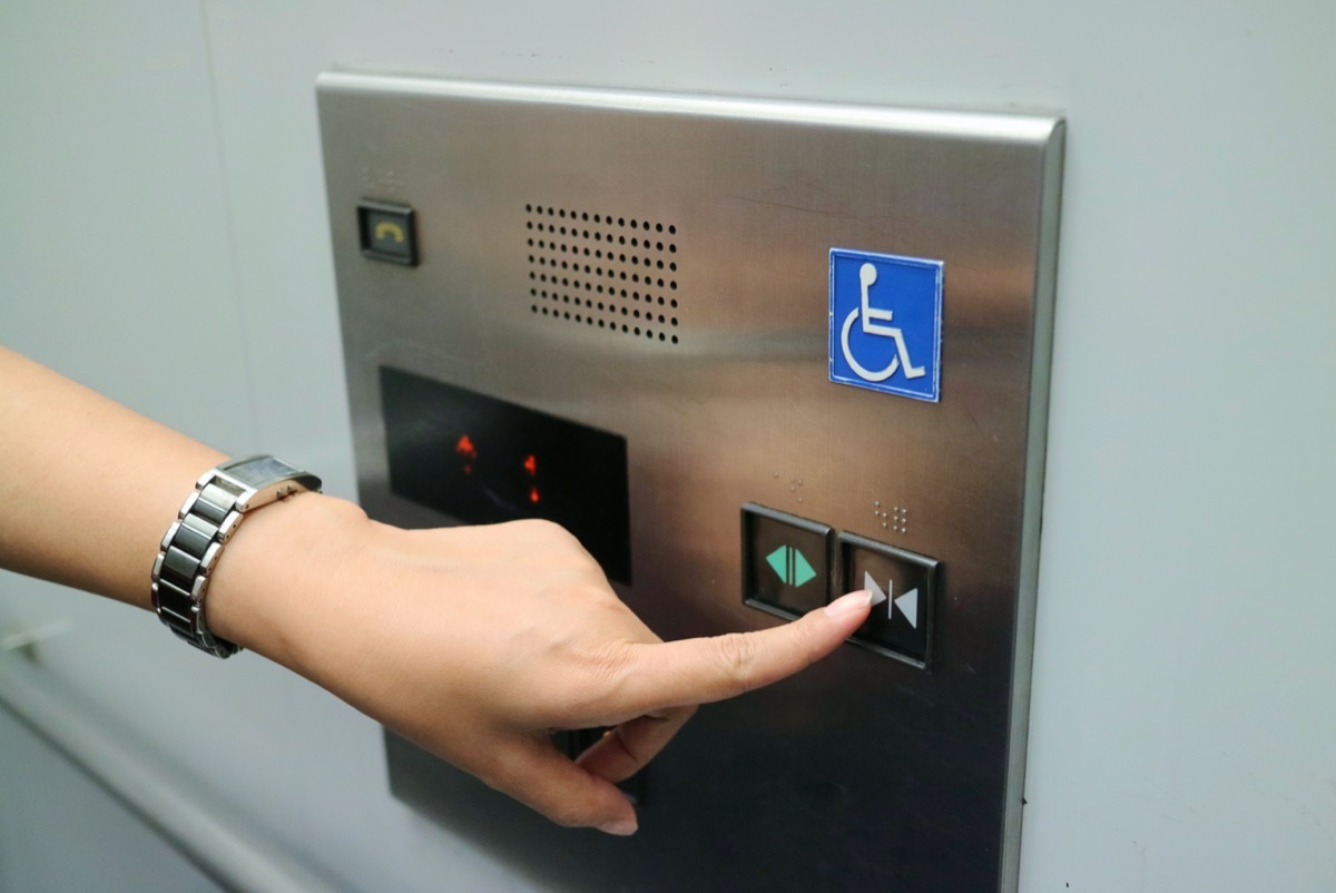 woman's hand pressing elevator button