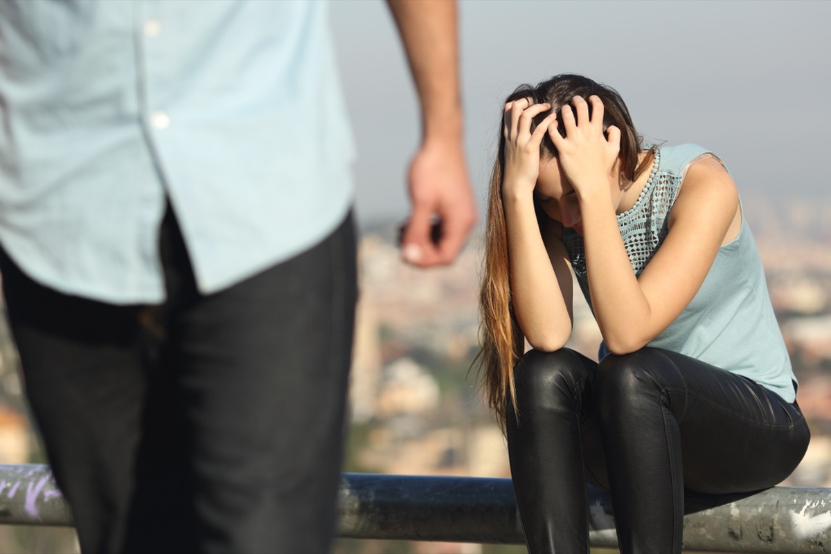 Woman with her head in her hands crying about a breakup. 