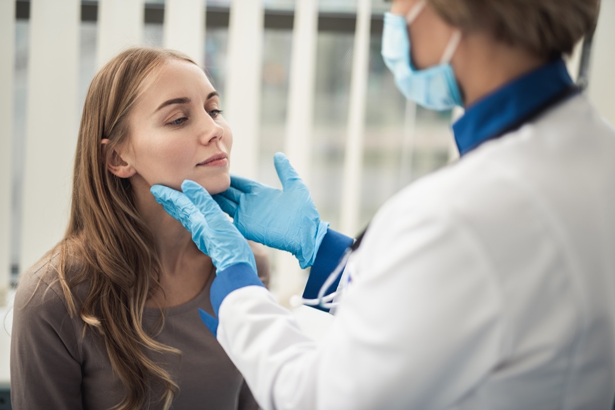 woman getting her tonsils checked by a doctor