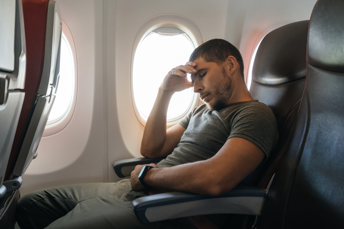 Airplane passenger using both armrests.