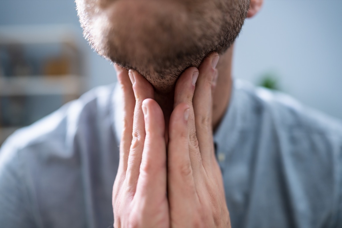 Close-up Of A Man's Hand Touching His Sore Throat