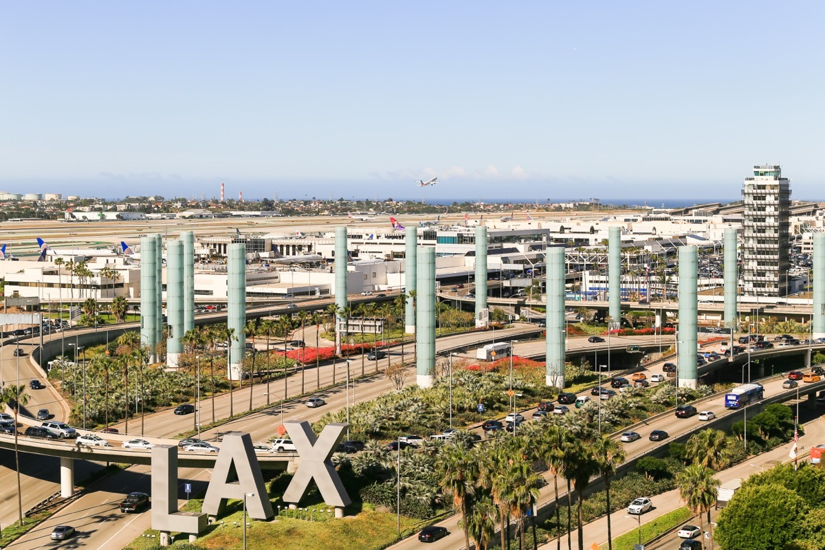 LOS ANGELES, CALIFORNIA, USA - MAY 22, 2019: The Los Angeles International Airport with its streets, entrances and exits. In the foreground is the LAX-sign. Captured from above.