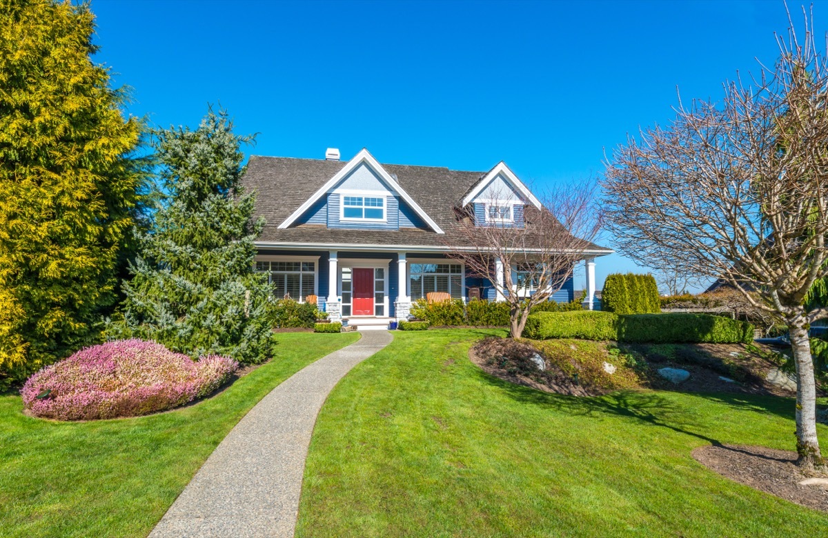 blue home with walkway through lawn