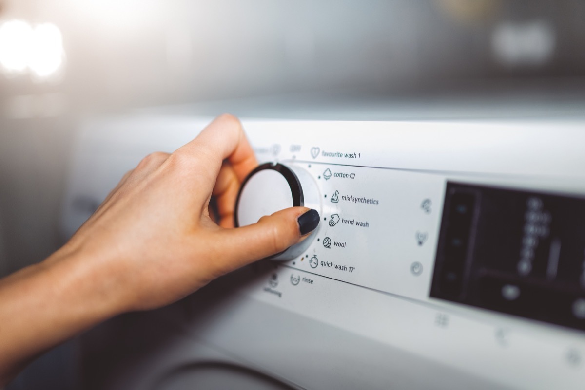 woman choosing washing cycle