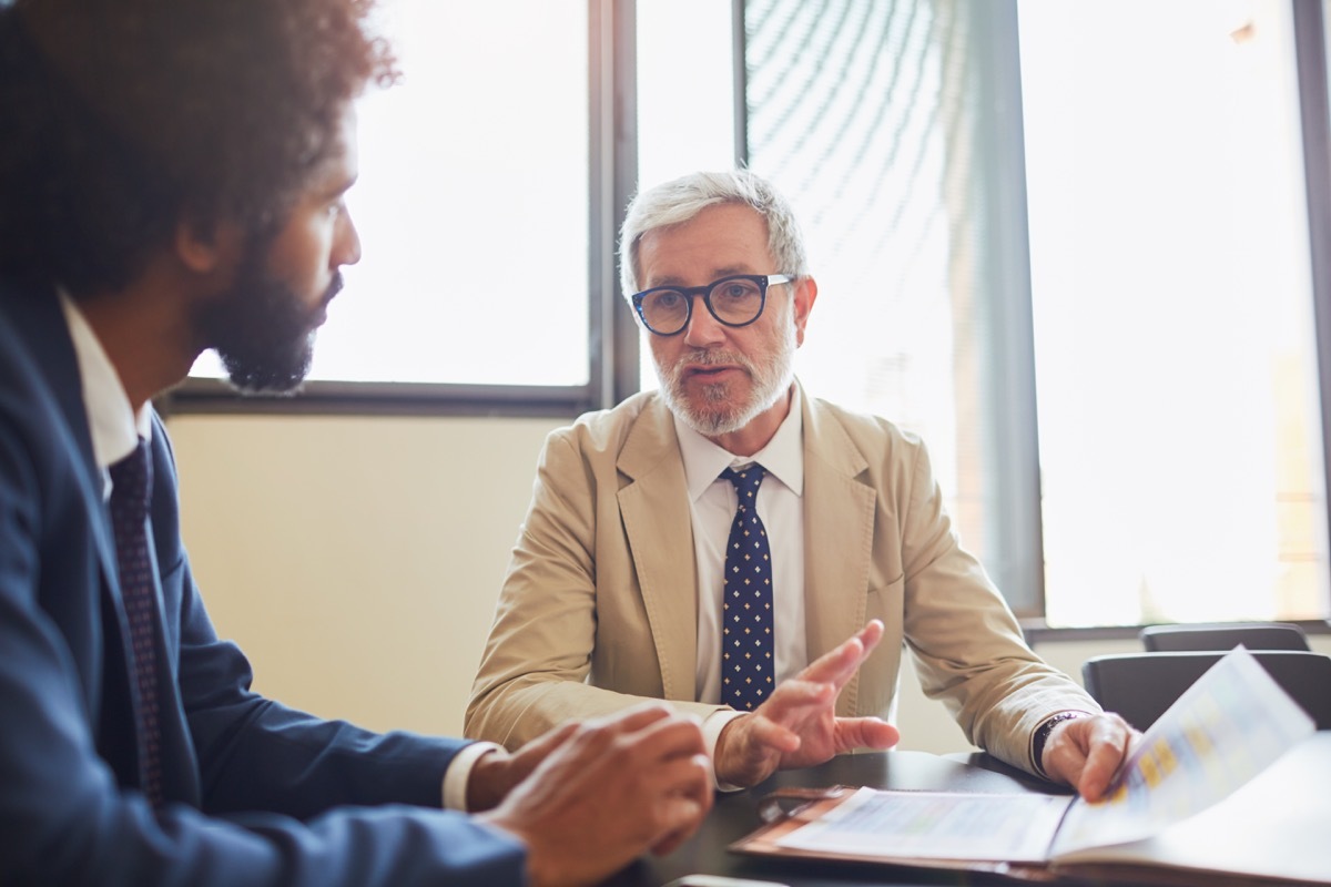 man seriously talking to his boss who appears to be upset